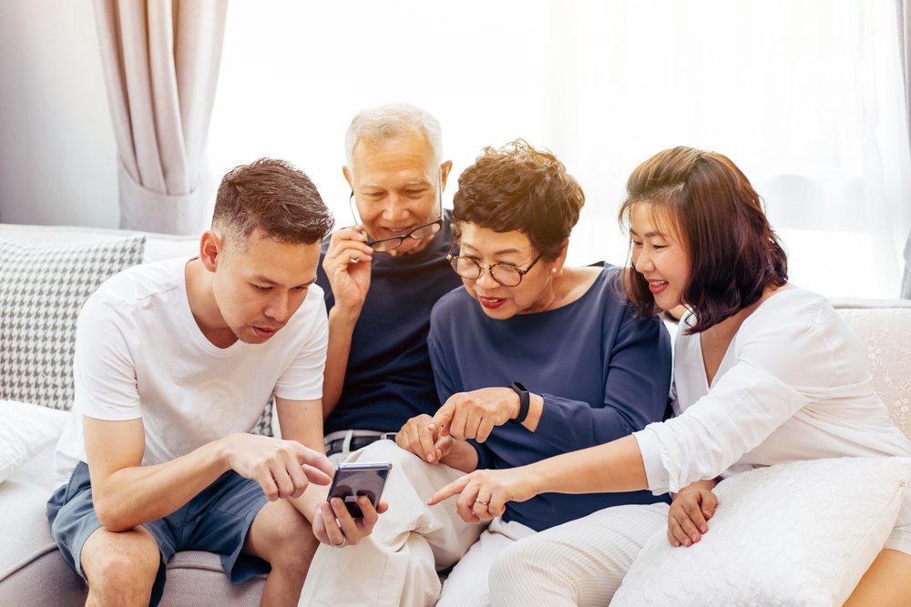 Asian Family with Adult Children and Senior Parents Using a Mobi